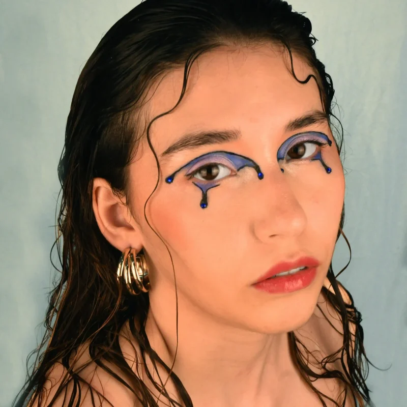 Editorial makeup photography in close-up and three-quarter angle, highlighting the makeup details and the model's expression from a dynamic angle.